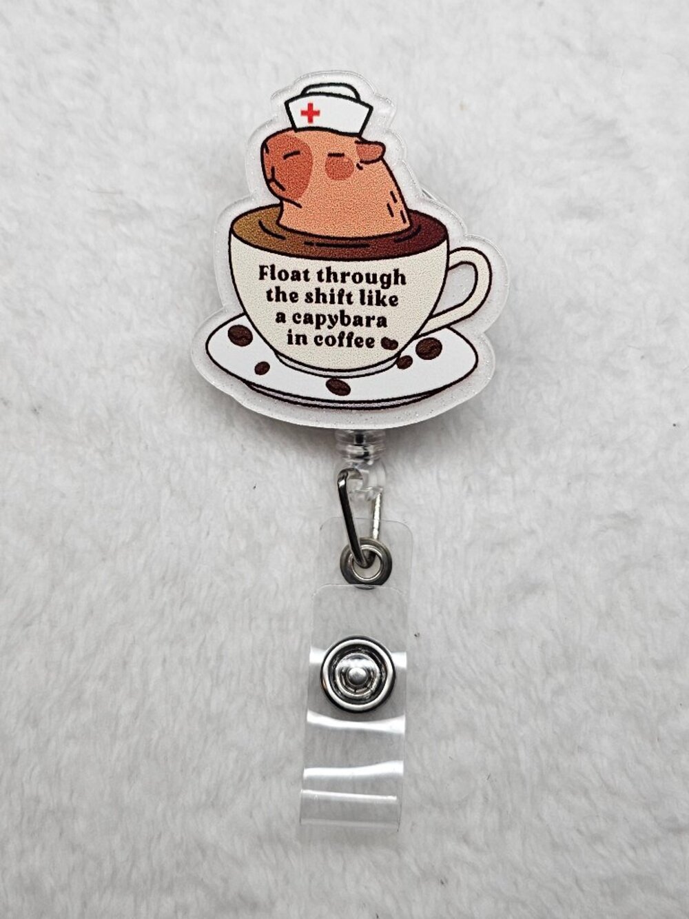 Retractable nurse ID badge reel featuring a cartoon capybara